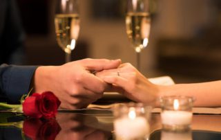 A couple holding hands at a romantic restaurant in Estes Park on a Valentine's Day getaway