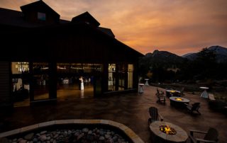 A newlywed couple enjoying their first dance at an event venue in Estes Park, with mountains in the background