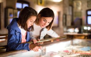 A mother and daughter looking at artifacts at a museum in Estes Park