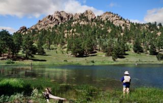 A man fishing in a lake in Rocky Mountain National Park