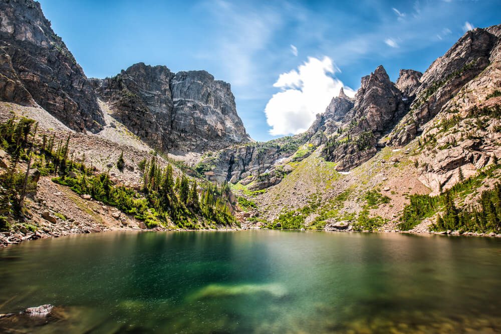 A hike to a lake with a mountain backdrop in Rocky Mountain National Park on a summer bucket list