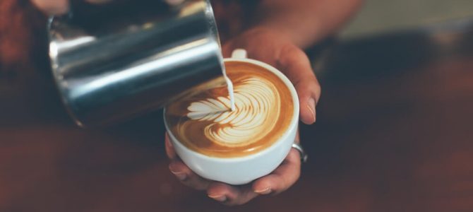 A barista pouring a cup of coffee at an Estes Park coffee shop
