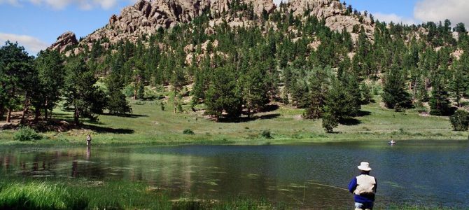 A man fishing in a lake in Rocky Mountain National Park